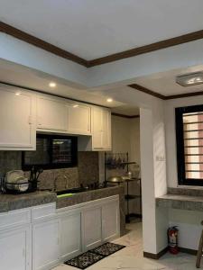 a kitchen with white cabinets and a counter top at CasaCavite - Your Chill Hideaway and Mini-Resort Just Minutes from all the Tagaytay-Silang-Nuvali Action! in Silang