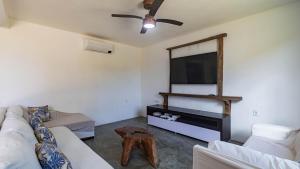 un soggiorno con divano e TV a schermo piatto di Casa c piscina em condominio na Praia do Espelho a Praia do Espelho Altre 42 foto