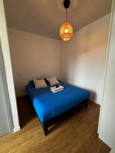 a bedroom with a blue bed in a room at Le Nébula - rénové - parking - proche centre ville in La Roche-sur-Foron