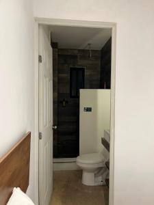 a bathroom with a white toilet in a room at Coco Live Suites in Playa del Carmen