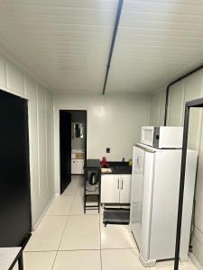 a kitchen with a white refrigerator in a room at Loft c/ Ar no Centro (2 camas) in Jaú