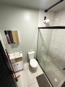 a bathroom with a toilet and a glass shower at Loft c/ Ar no Centro (2 camas) in Jaú