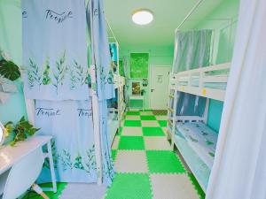 a room with bunk beds and a green and white floor at Figo's Family Youth Hostel in Harbin