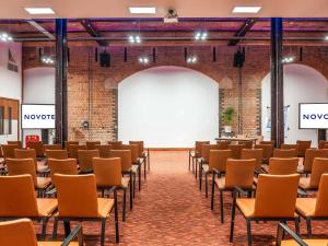 an empty room with rows of chairs and a stage at Novotel Cardiff Centre in Cardiff +214 photos