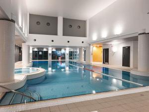 a large swimming pool in a large building at Novotel Cardiff Centre in Cardiff