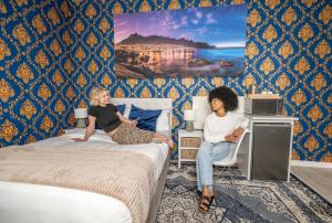 2 femmes assises sur des lits dans une chambre d'hôtel dans l'établissement Prime Executive Accommodation, au Cap