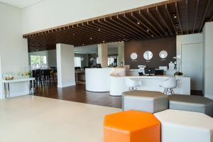 Un vestíbulo de oficina con un mostrador naranja y blanco. en Transamerica Wise Indaiatuba, en Indaiatuba