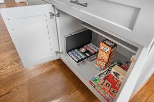 a drawer in a kitchen cabinet filled with toys at Homey Apt Nr Med Center Fire Pit Bbq Wifi Games in Houston
