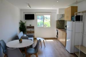a kitchen with a table and chairs and a white refrigerator at Estudio Finca Mas el Bravo in Caudiel