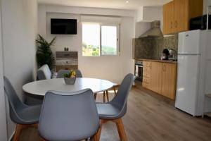 a kitchen with a table and chairs and a white refrigerator at Estudio Finca Mas el Bravo in Caudiel +14 photos