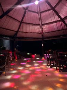 a room with a tent with tables and chairs and lights at Finca Lago Calima in Yotoco
