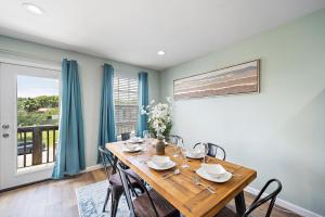 ein Esszimmer mit einem Holztisch und Stühlen in der Unterkunft Elevated Stay Near Pier, Beach Bbq Wifi Games in Galveston