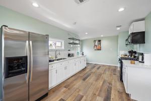 eine Küche mit einem Edelstahlkühlschrank und weißen Schränken in der Unterkunft Elevated Stay Near Pier, Beach Bbq Wifi Games in Galveston + 28 Fotos