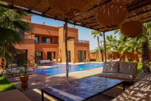 a villa with a swimming pool and a house at VILLA NOÛR PALACE avec piscine jaccuzi à Marrakech in Marrakech