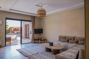 a living room with a couch and a table at VILLA NOÛR PALACE avec piscine jaccuzi à Marrakech in Marrakech