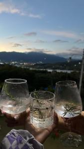 two hands holding two wine glasses with water at Finca Lago Calima in Yotoco