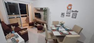 a living room with a table and a dining room at Precioso Lar 2 in Gramame