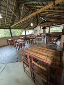 a dining room with wooden tables and chairs at Recanto Vale Minã in Lavrinhas