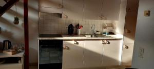 Una pequeña cocina con gabinetes blancos y un fregadero. en Holiday Home Dragonfly, en Quartino