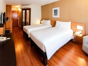 a hotel room with two beds and a couch at Novotel Lima San Isidro in Lima +137 photos