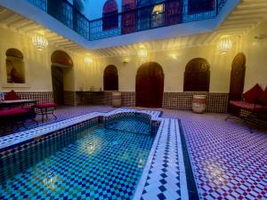 a large swimming pool in a building with a pool at Riad Prada in Marrakech