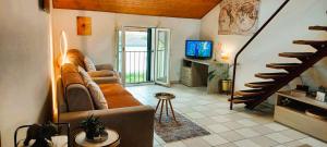 a living room with a couch and a staircase at Holiday Home Dragonfly in Quartino