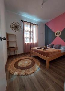 a bedroom with a bed and a rug on the floor at Caza Villana in Rodrigues Island +9 photos