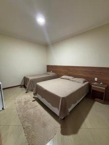 a bedroom with two beds and a rug at Recanto Vale Minã in Lavrinhas +18 photos