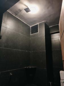 a dark bathroom with a toilet and a light at SHIV SHAKTi HOMESTAY in Kevadia +9 photos