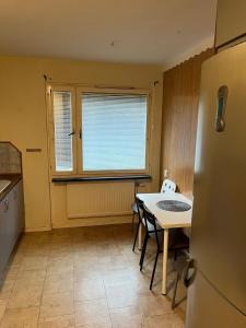 Una cocina con refrigerador y una mesa con sillas. en Biskopsgarden, en Gotemburgo 3 fotos más