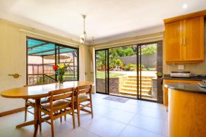 a kitchen with a table and chairs and a large window at Spacious and homely 4-bed home in Honey Hills in Roodepoort