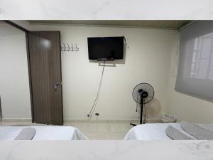a room with two beds and a flat screen tv at Casa amoblada 15 personas 6 habitaciones 4 baños - Frente al terminal y cable aereo, Cerca de Expoferias, Bosque Popular y Termales del Otoño in Manizales