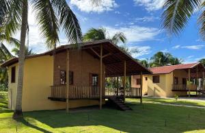 a house with a porch and a palm tree at Bio-Resort Brasilien in Trairi