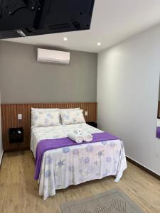 イーリャ・グランデにあるSuítes Refúgioのベッドとタオル2枚のある寝室