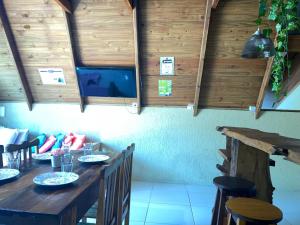 a dining room with a table and a tv at Chalé com Piscina e Natureza Primavera Rosa in Penha