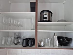 a cupboard with wine glasses and a coffee maker at Domspitze in Schwerin