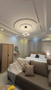 a bedroom with a large bed and a couch at Rest home in Tabuk