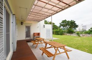 a patio with two picnic tables on a house at I will meet Hyakuna, - Vacation STAY 33599v in Nanjo