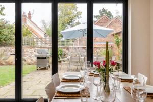 a table with plates and glasses and an umbrella at Dune House in Brancaster