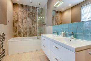 a bathroom with a sink and a tub and a shower at Dune House in Brancaster +26 photos