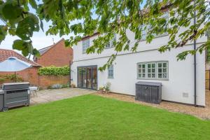 a house with a lawn in front of it at Dune House in Brancaster
