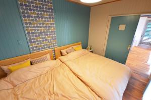 a bedroom with a large bed with yellow sheets at I will meet Hyakuna, - Vacation STAY 33599v in Nanjo