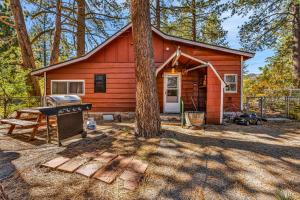 a red cabin with a grill and a tree at Green Cabin in Big Bear Lake 3 bdr Pets Friendly in Big Bear City