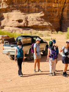 a group of people standing in front of a car at Wadi Rum Abu Khaled in Wadi Rum