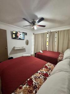 a bedroom with two beds and a ceiling fan at Hotel Miranda in La Concepción