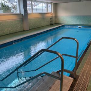 a large swimming pool with a staircase in a building at Christine's Apt.115 in Sonthofen