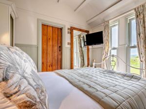 a bedroom with a bed and a tv and a window at 1 Bed in Boscastle 95316 in Camelford