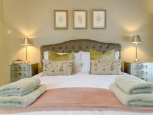 a bedroom with a white bed with two night stands at 1 Bed in Wool 88099 in Wool