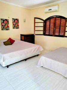 a bedroom with two beds and a window at Casa amarela com fundos para seminário in Aparecida