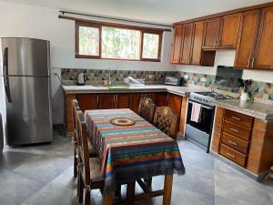 コタカチにあるCasa Blanca departamentoのテーブルとステンレス製の冷蔵庫を備えたキッチン